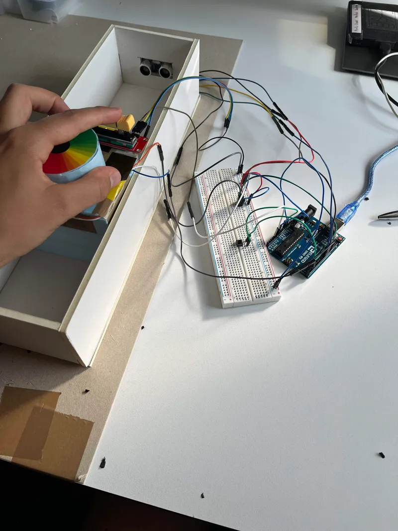 Hand holding the round colour dial next to the Arduino wiring on a breadboard