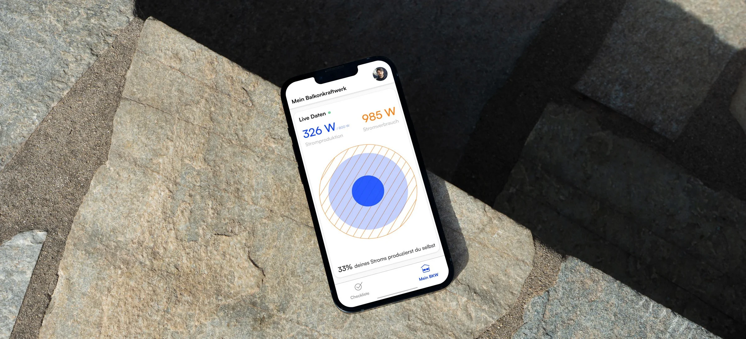 Smartphone lying on a rock, showing the SimpleSolar live data screen with current solar output