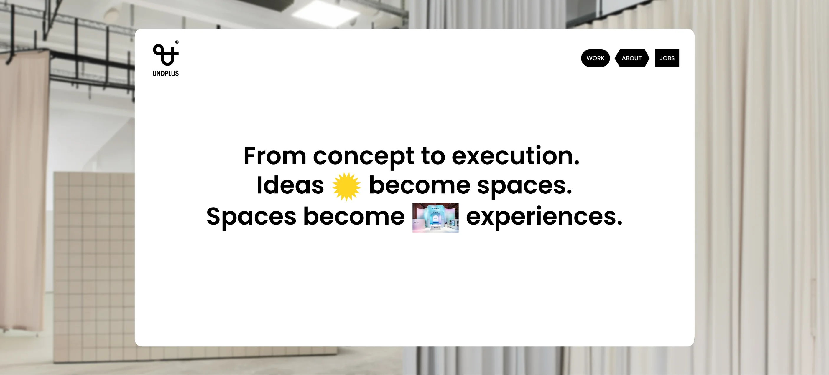 Start of the UNDPLUS website on a white panel in front of a room with curtains: “From concept to execution. Ideas become spaces. Spaces become experiences.”